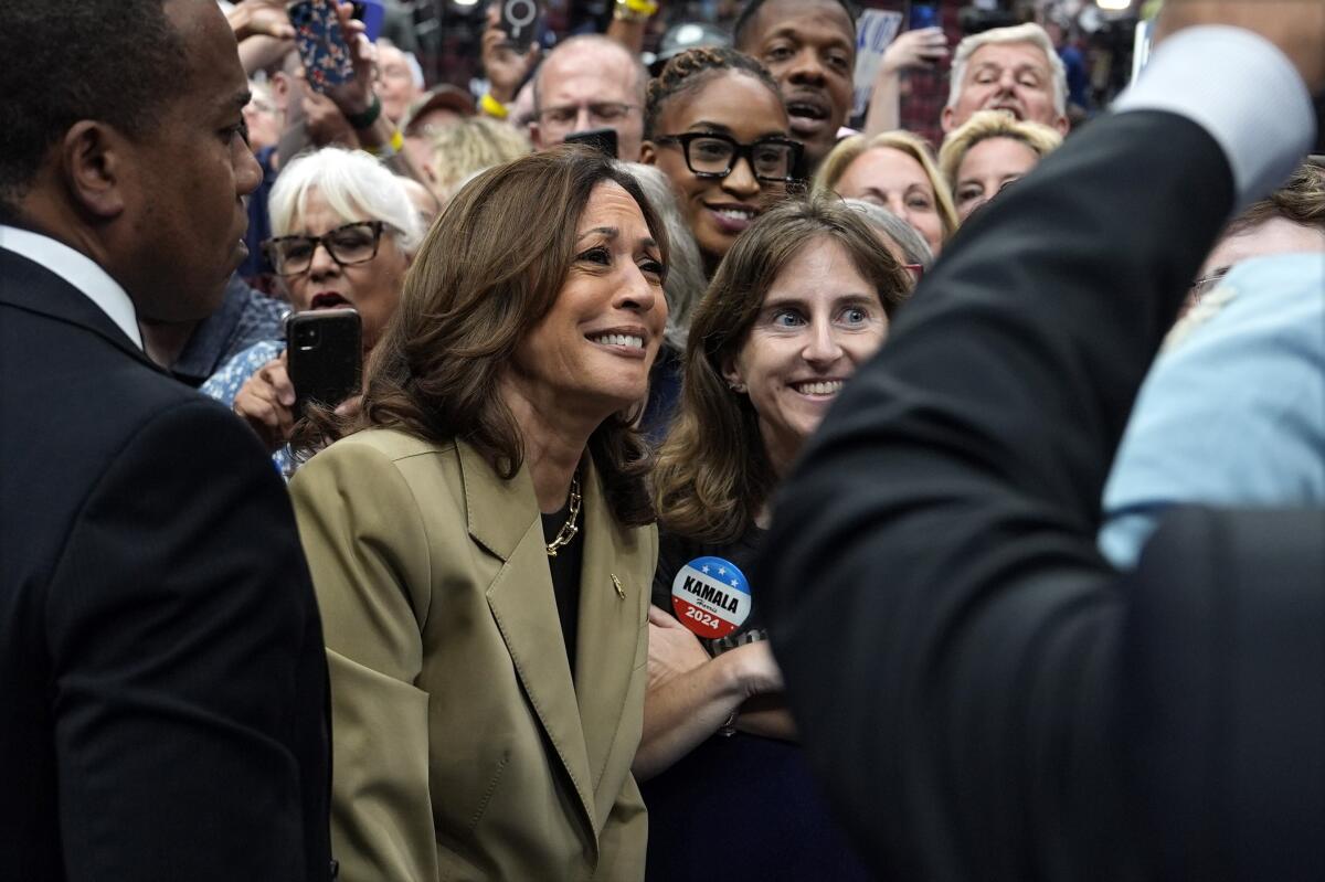 La vicepresidenta Kamala Harris posa para fotos con sus simpatizantes en un mitin