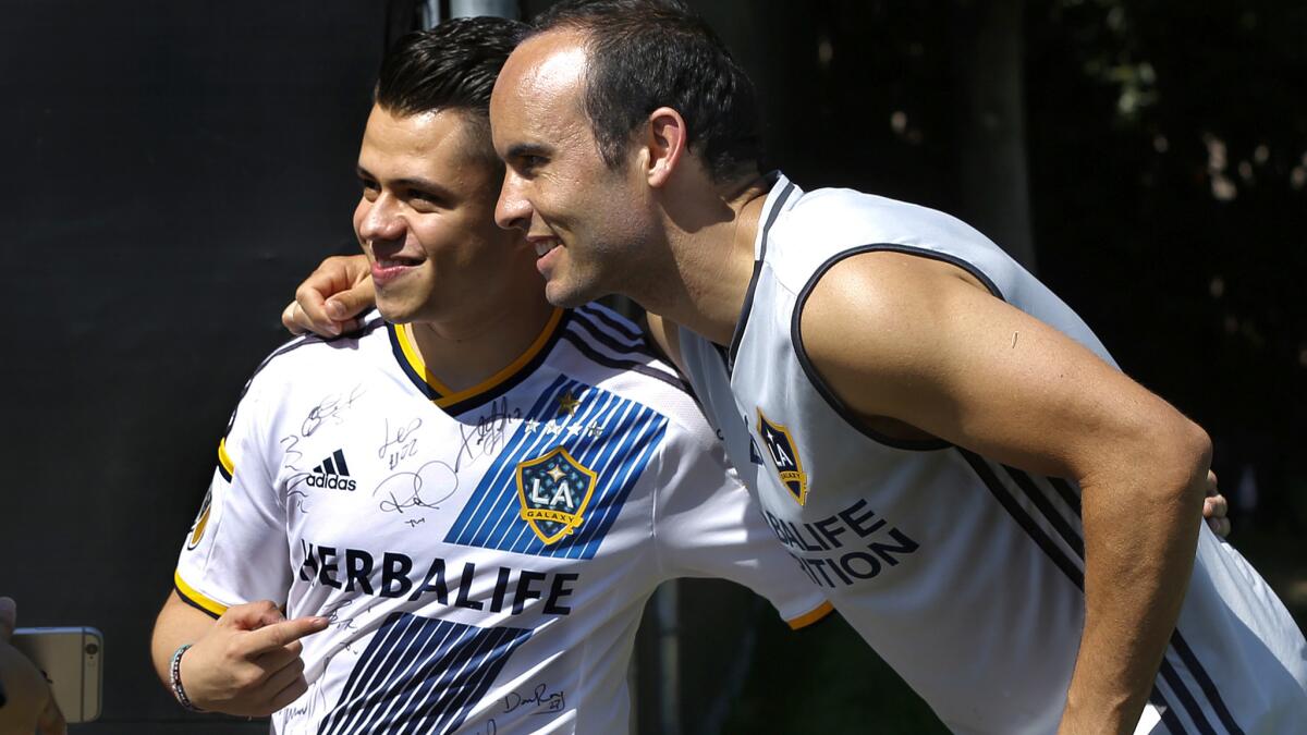 Landon Donovan poses for a photo with Galaxy fan Jiovanny Lopez after practice Friday.