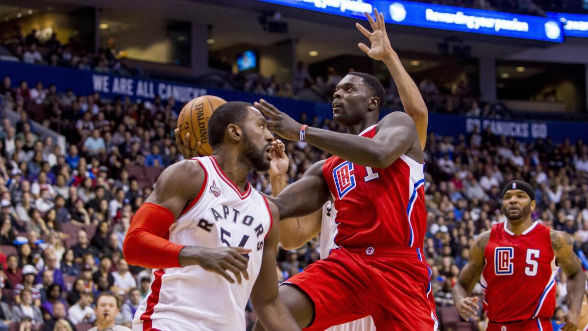 Clippers guard Lance Stephenson attempts a layup by splitting two Raptors defenders during their exhibition game Sunday night in Vancouver.