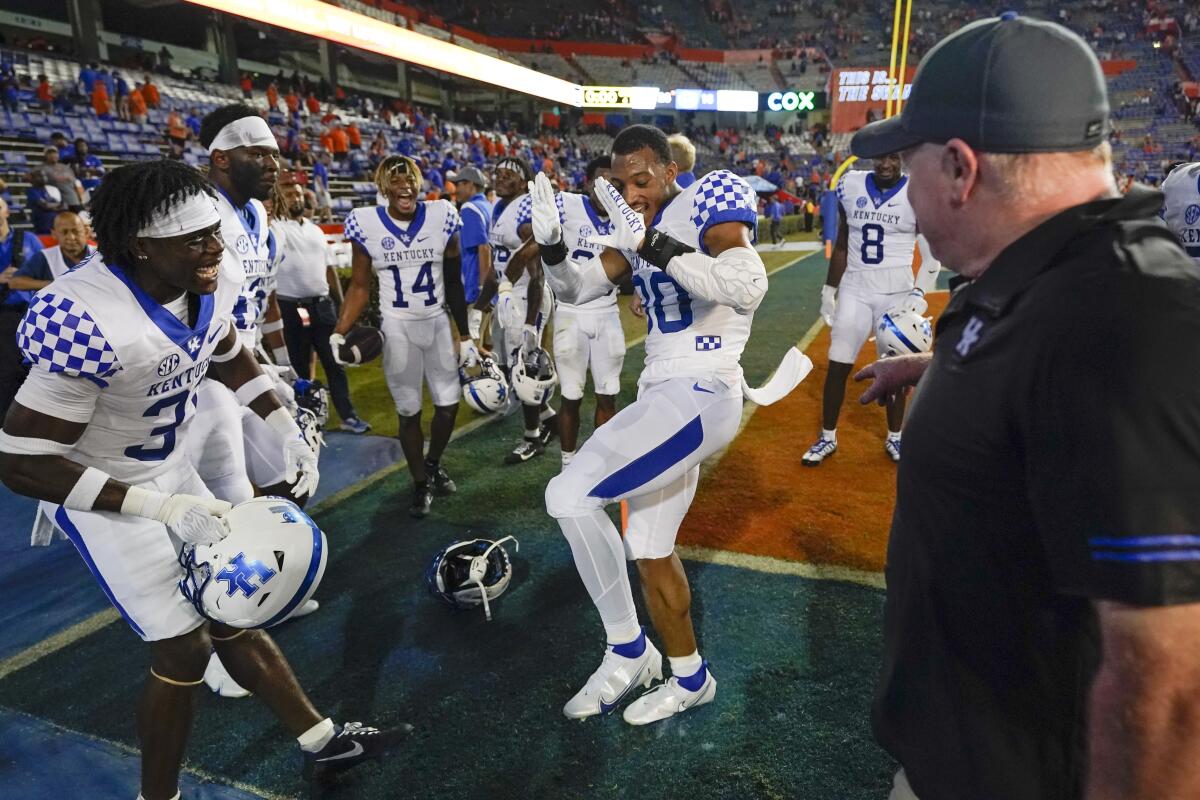 Kentucky coach Mark Stoops, right, watches his players dance in celebration after beating Florida.