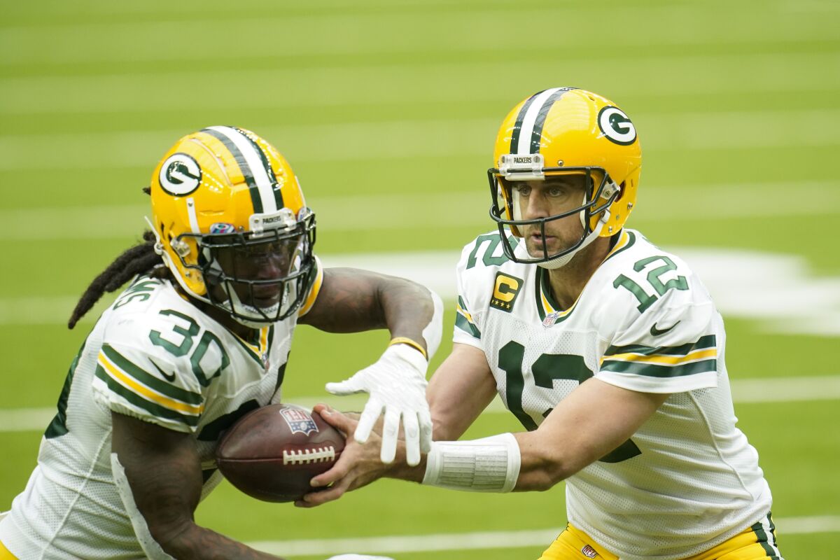 Green Bay Packers quarterback Aaron Rodgers hands off the ball to Jamaal Williams.