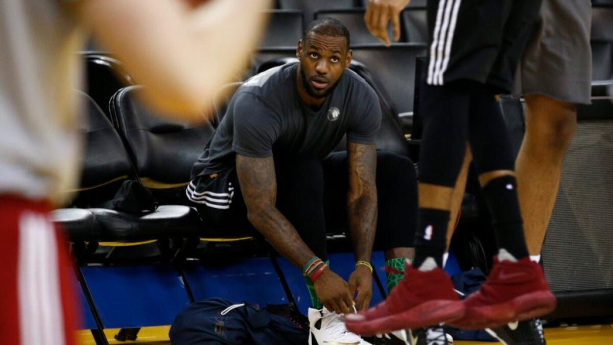 Cleveland forward LeBron James puts on his shoes during a practice ahead of Game 7 against the Warriors on June 18.