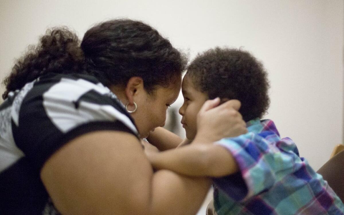 Research at the Marcus Autism Center in Atlanta indicates that children with autism begin to lose interest in eye contact as early as 2 months of age. Here, Marlaina Dreher makes eye contact with her 5-year-old son, Brandon, during a therapy session at the Atlanta center.