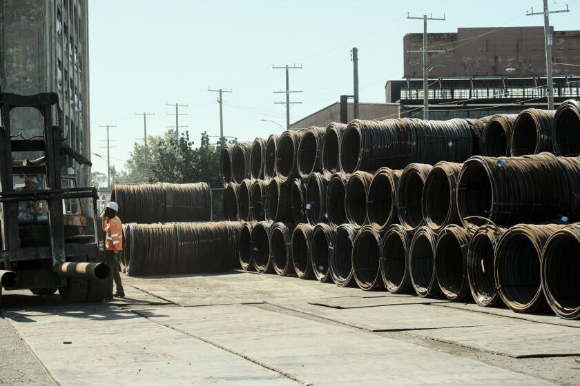 Workers unload bar-in-coil steel from a ship in the dockyard at the Port of Detroit in Detroit, Michigan.