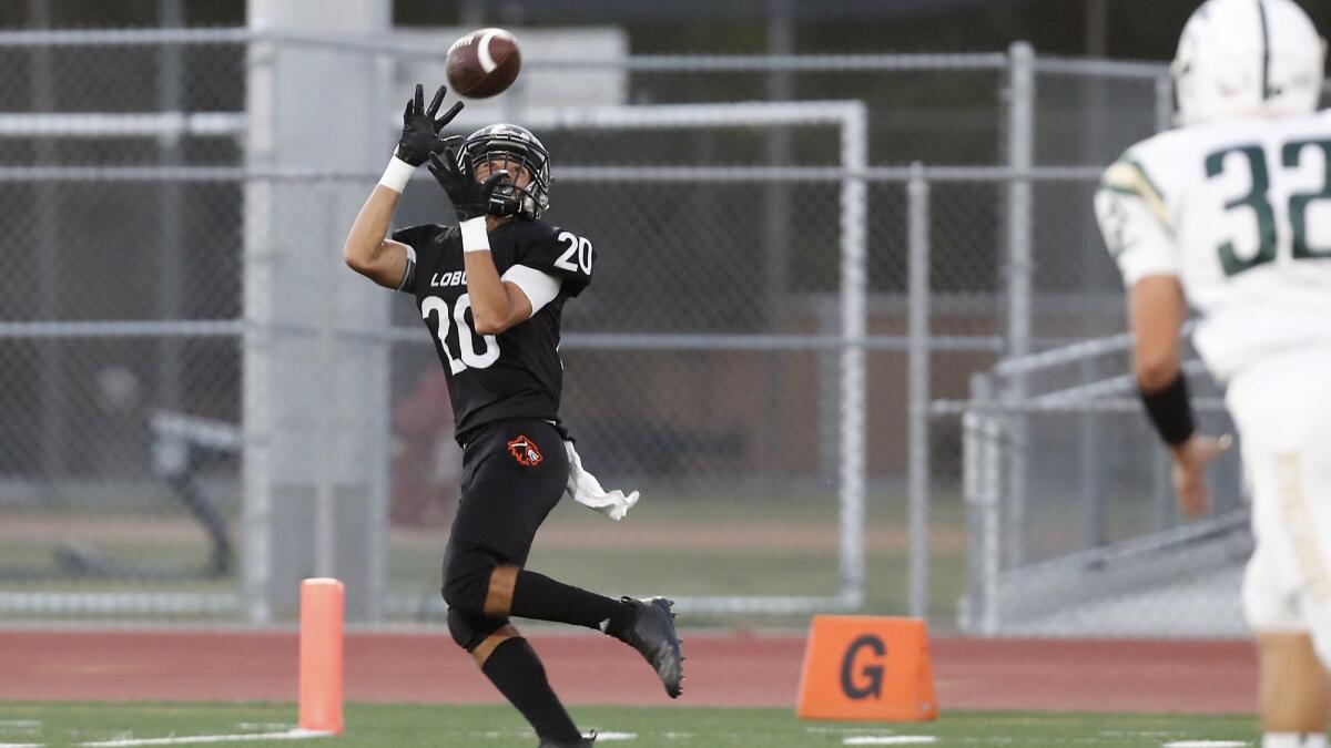 Los Amigos High receiver Adolfo Chavez, shown catching a touchdown pass against Saddleback on Sept. 6, will try to help the Lobos win their Garden Grove League opener against La Quinta on Friday.