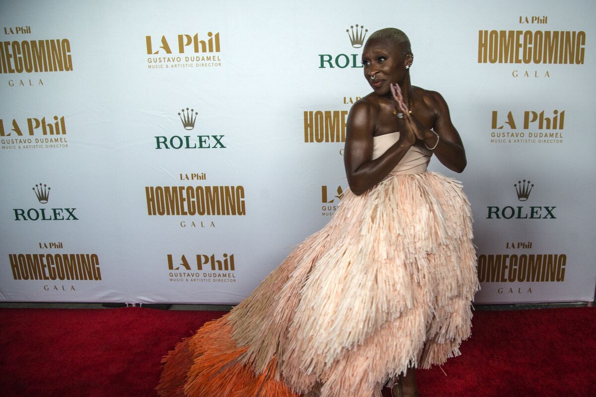 Cynthia Erivo stands on a red carpet in a strapless gown with a voluminous, feathery skirt.