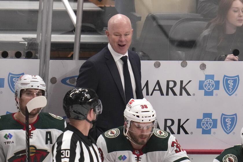 FILE - Minnesota Wild head coach John Hynes talks with referee Kendrick Nicholson (30) during the first period of an NHL hockey game against the Pittsburgh Penguins in Pittsburgh, Monday, Dec. 18, 2023. John Hynes of the Minnesota Wild has been named the coach of the 2024 U.S. men’s national team for the upcoming IIHF Men’s World Championship next month in Czechia. USA Hockey announced the appointment on Friday, April 19, for the event that will take place from May 10-26. (AP Photo/Gene J. Puskar, File)