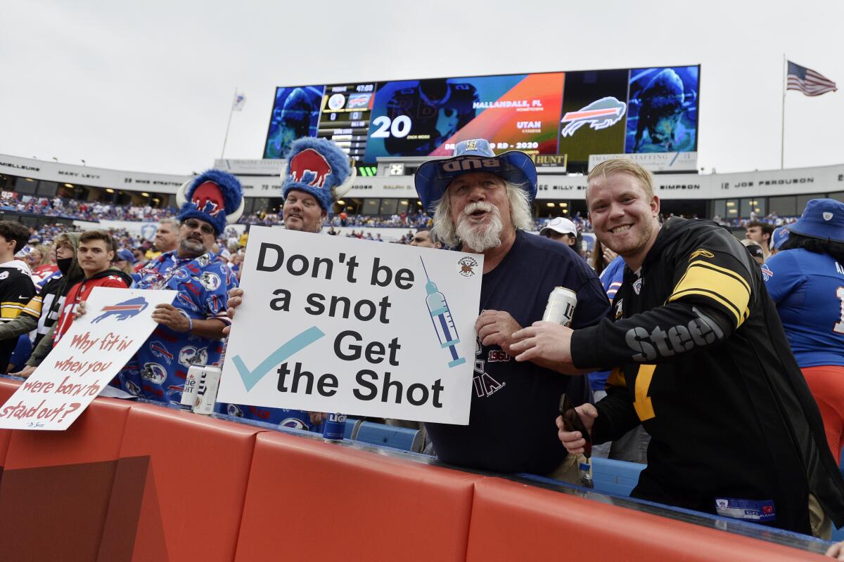 Fans holds signs during the first half of an NFL football game between the Buffalo Bills and the Pittsburgh Steelers in Orchard Park, N.Y., Sunday, Sept. 12, 2021. (AP Photo/Adrian Kraus)