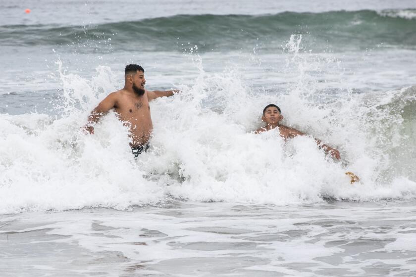 Imperial Beach Pier, CA - July 29: Israel Juarez, 27, and his younger brother Omar Juarez, 10, swim near the Imperial Beach Pier in Imperial Beach, CA on Friday, July 29, 2022. The two brothers came to San Diego from Mesa, Arizona to enjoy the beaches and other tourist attractions. Israel said there weren't aware the sewage problem in Imperial Beach and didn't see the signs warning visitors of possible water contamination. "If I saw them, I would've probably just turned around," he said. "I'd still walk to beach and stuff like that, but I probably wouldn't go in the beach." (Adriana Heldiz / The San Diego Union-Tribune)