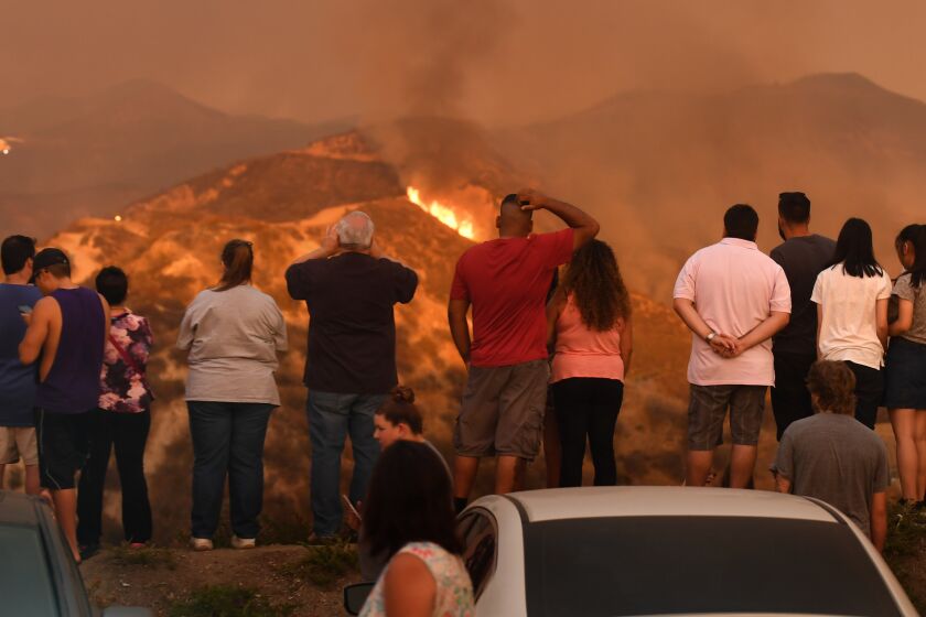 Evacuated residents watch as the Sand fire burns in the San Gabriel Mountains on Sunday.