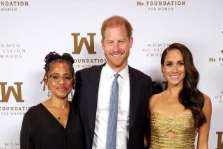 Doria Ragland, left, son-in-law Prince Harry and daughter Meghan Markle stand together, posing for photo, smiling. 