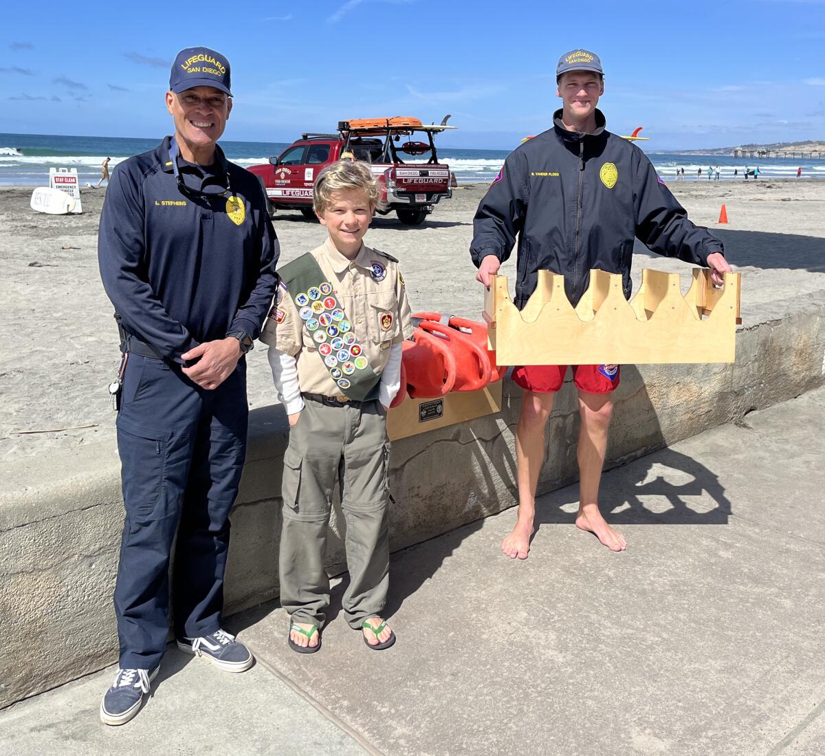 Eagle Scout Emilio De Soto and lifeguards Lonnie Stephens and Benjamin Vander Ploeg show Emilio's custom buoy holder.