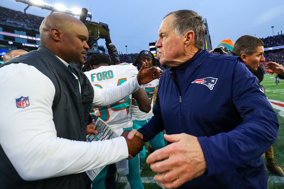 Miami Dolphins coach Brian Flores shakes hands with New England Patriots coach Bill Belichick.