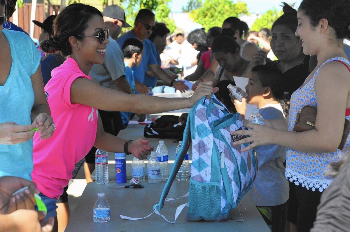 Volunteers distribute backpacks to low-income families during the Share Our Selves Back to School Program in August.