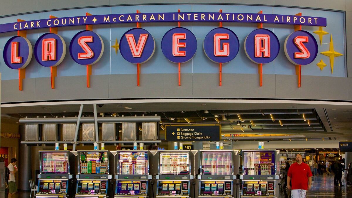 Slot machines beckon travelers at McCarran International Airport. (George Rose / Getty Images)