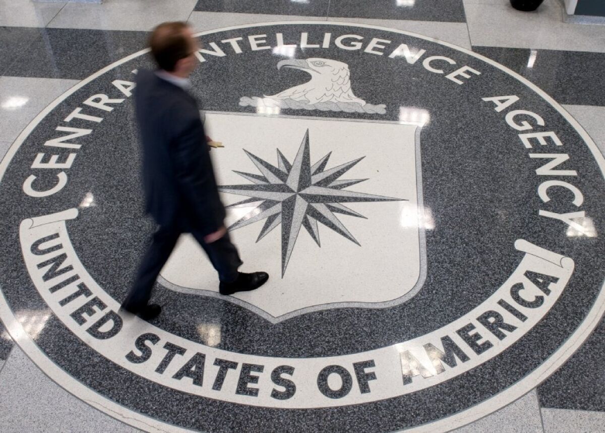 A man crosses the Central Intelligence Agency logo in the lobby of CIA Headquarters in Langley, Va.
