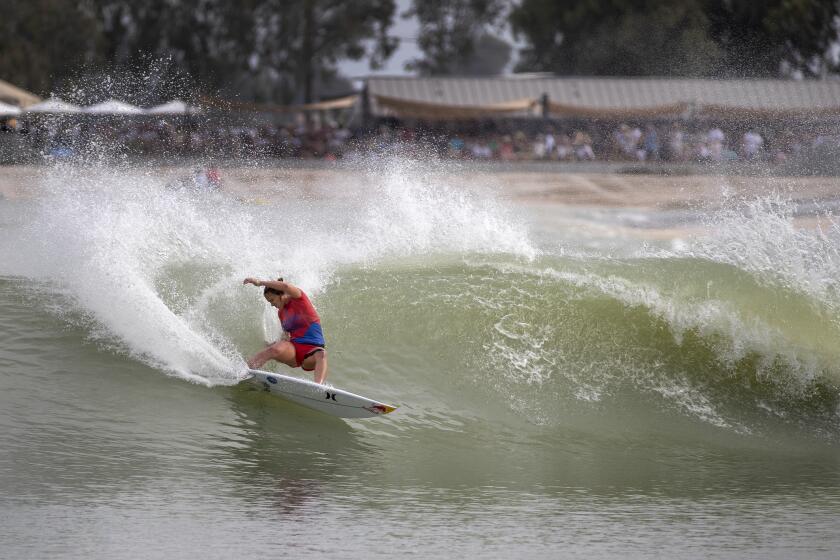 LEMOORE, CALIF. -- SATURDAY, MAY 5, 2018: Carissa Moore, of Hawaii and competing for Team U.S.A., does a slashing turn during her high-scoring 9.27 wave at the first-ever World Surf League Founder's Cup at Kelly Slater's Surf Ranch in Lemoore, CA., about 100 miles from the ocean. Event finals are Sunday. The Founder's Cub is a historic region-versus-region teams event featuring a cross-section of the world's best surfers. This same (or similar) technology may be used in Tokyo for the 2020 Olympics.Kelly Slater (USA), 11-time WSL Men's Champion, will lead the US men's and women's team at the Founders' Cup. Five teams - USA, Brazil, Australia, Europe and World - made up of men's and women's surfers from the elite WSL Championship Tour, will compete over the two-day event at the world-class, man-made wave venue of Surf Ranch in Lemoore, California. The competition will be hosted against a festival backdrop honoring the culture of surfing - food, music, beverage, art and special guests. The Surf Ranch facility, which was revealed online to the public in December 2015, boasts the best man-made wave in history - a 700-yard, high-performance, bi-directional wave featuring barrel sections and maneuver sections. Primarily existing as a testing facility, the Lemoore site has spent the past two years dialing in the technology under the guidance of 11-time WSL Champion Kelly Slater (USA) and feedback from visiting WSL surfers. A private test event last September proved very successful, paving the way for the May Founders' Cup of Surfing to be the first time the public will be allowed onto the grounds. (Allen J. Schaben / Los Angeles Times)