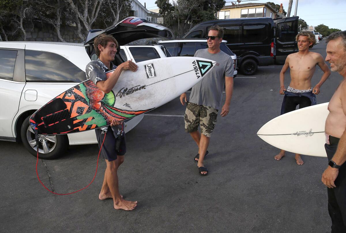 Brayden Belden, of Laguna Beach, chats with fellow surfers at Brooks Street after a surf session.