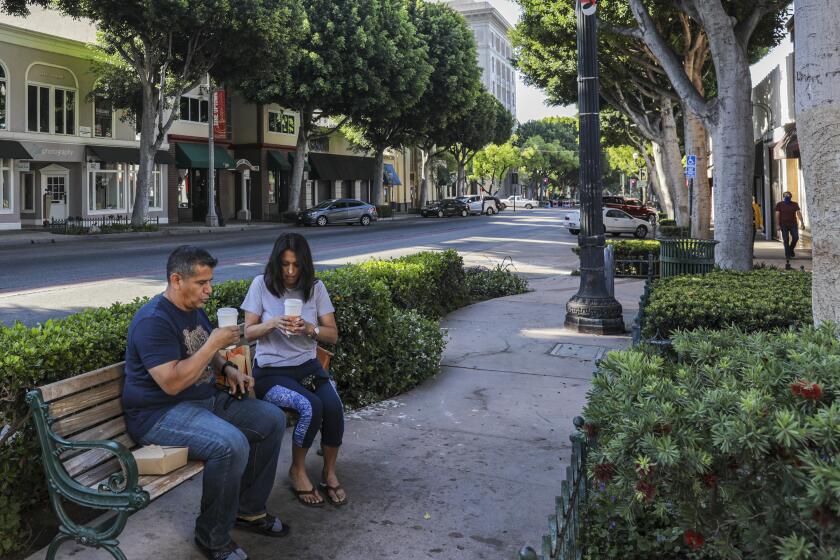 WHITTIER, CA - MAY 08: David Fernandez, left, and Yolanda Gallegos enjoy coffee from La Monarca Bakery that was open for take out order on Friday, May 8, 2020 in Whittier, CA. (Irfan Khan / Los Angeles Times)