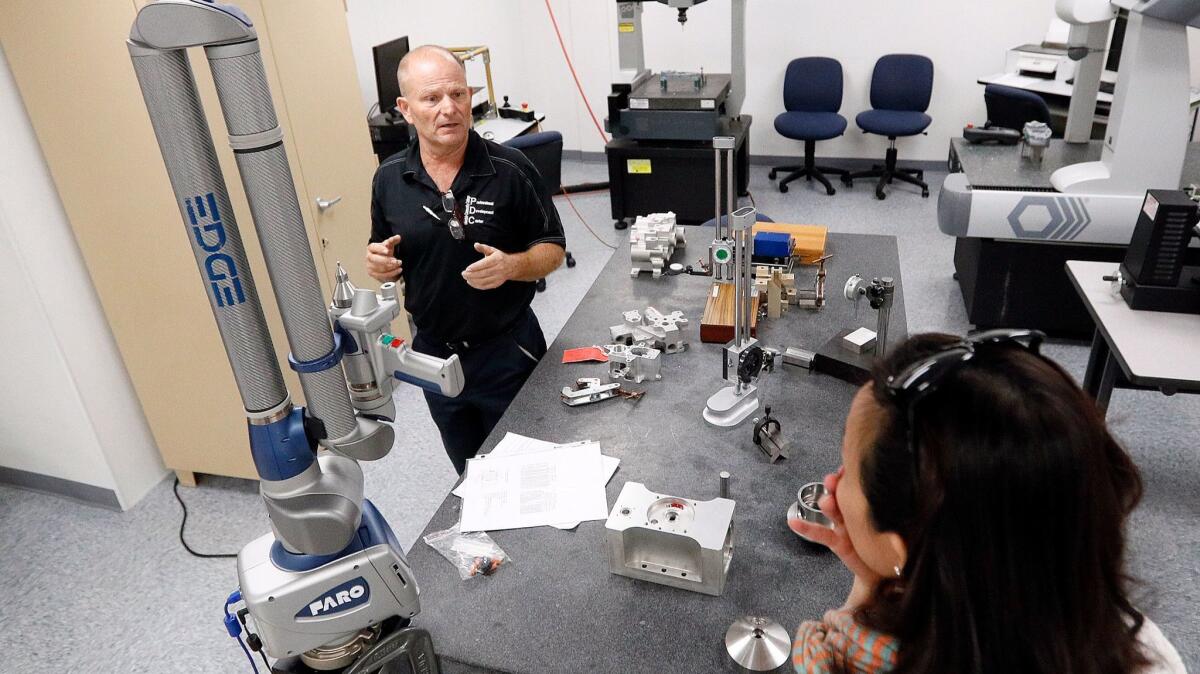 Manufacturing instructor Bill Roberto discusses the precise measurement equipment available to students with Kathleen Tang at the Professional Development Center of Glendale Community College in Montrose, one of the locations for the 2nd Annual Glendale Tech Week 2017 on Tuesday.