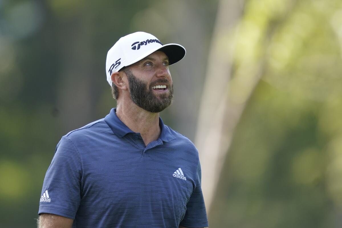 Dustin Johnson looks at the trees he hit his tee shot over on the 12 hole during the first round off the LIV Golf Invitational-Chicago tournament Friday, Sept. 16, 2022, in Sugar Grove, Ill. (AP Photo/Charles Rex Arbogast)