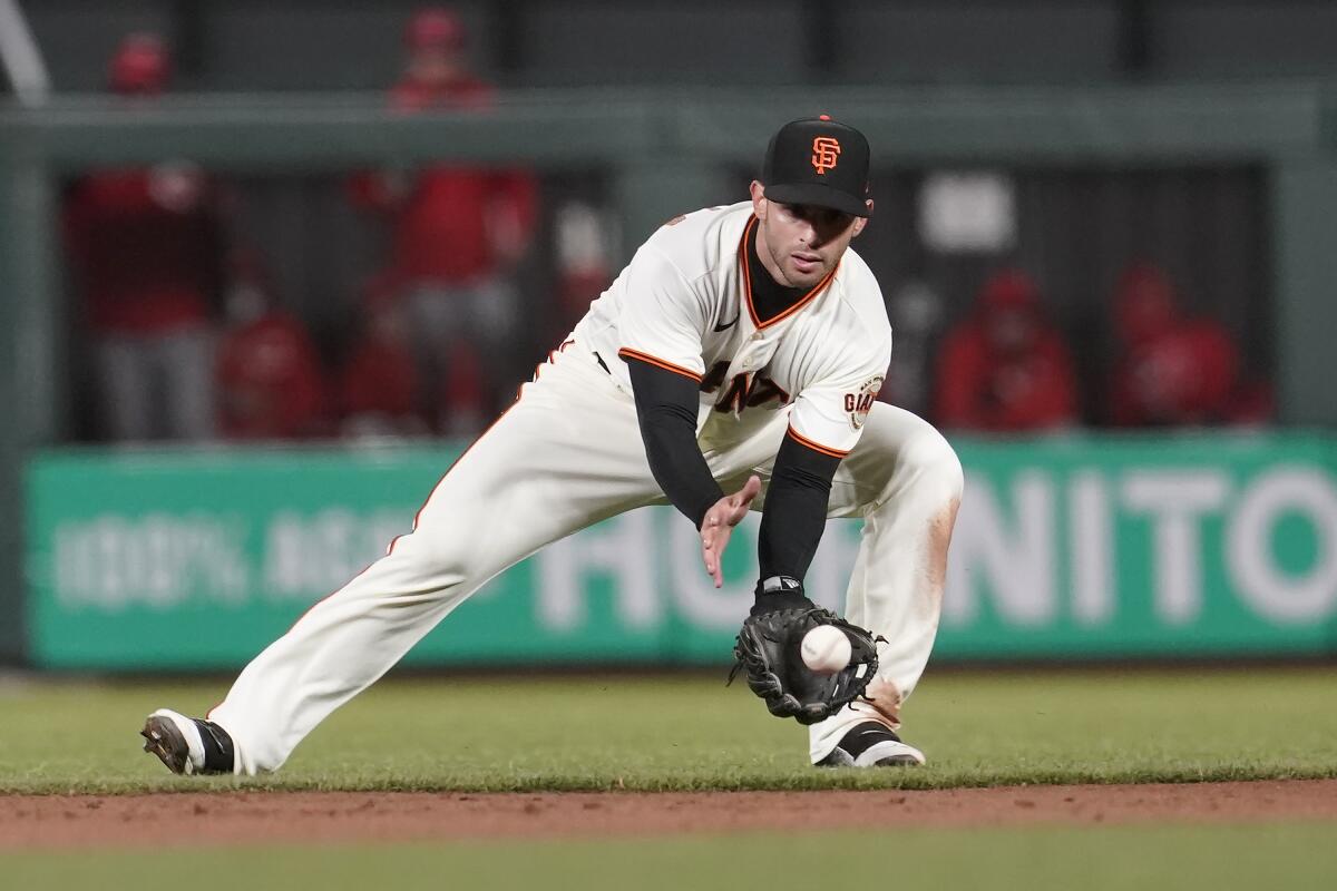 San Francisco Giants second baseman Tommy La Stella fields a grounder by Cincinnati Reds' Eugenio Suarez, who was out at first during the sixth inning of a baseball game in San Francisco, Tuesday, April 13, 2021. (AP Photo/Jeff Chiu)