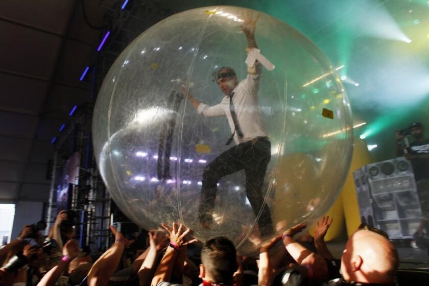 Walshy Fire, of the musical project Major Lazer, runs across the crowd in a plastic ball during Lazer's show in the Mojave Tent at Coachella.
