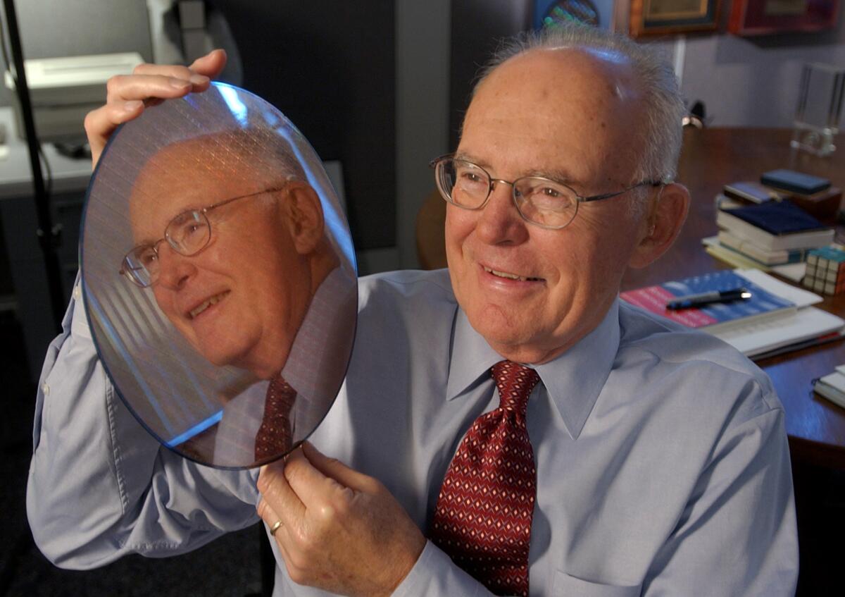 Intel Corp. co-founder Gordon Moore holds up a silicon wafer at Intel headquarters