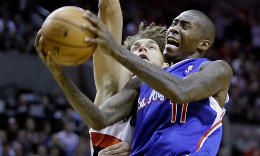 Clippers shooting guard Jamal Crawford, right, puts up a shot in front of Portland Trail Blazers center Robin Lopez during a loss on Dec. 26. Crawford is averaging 16.7 point per game this season.