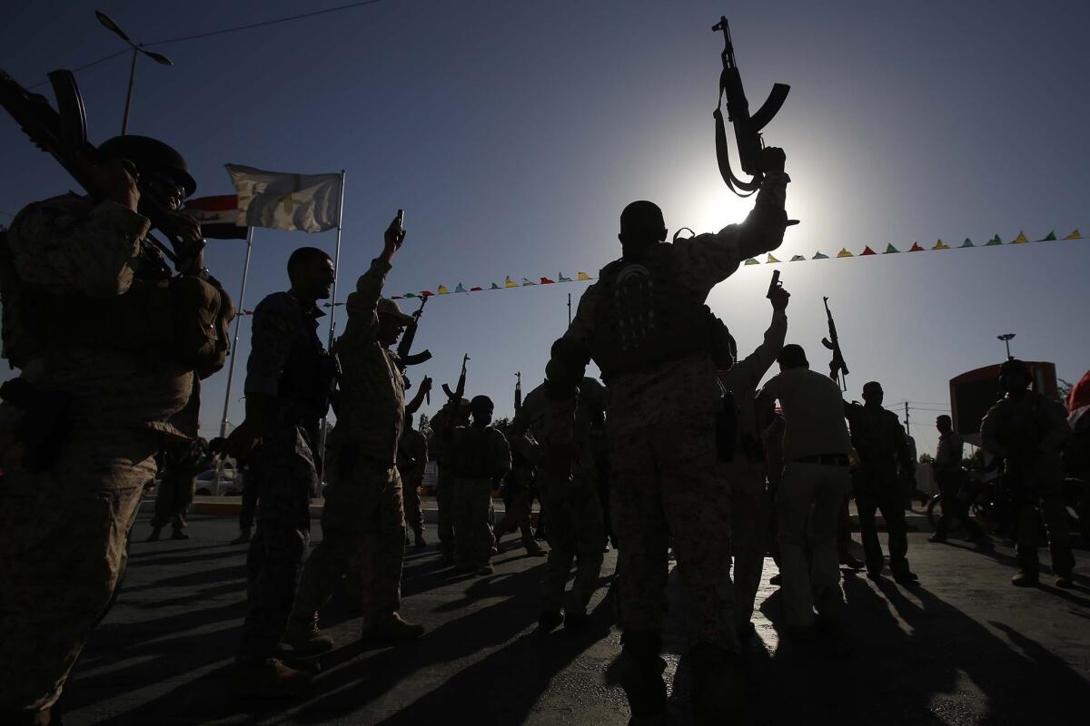 Iraqi fighters who volunteered to protect Shiite Muslim holy sites in Karbala against Sunni insurgents parade in the city Thursday.