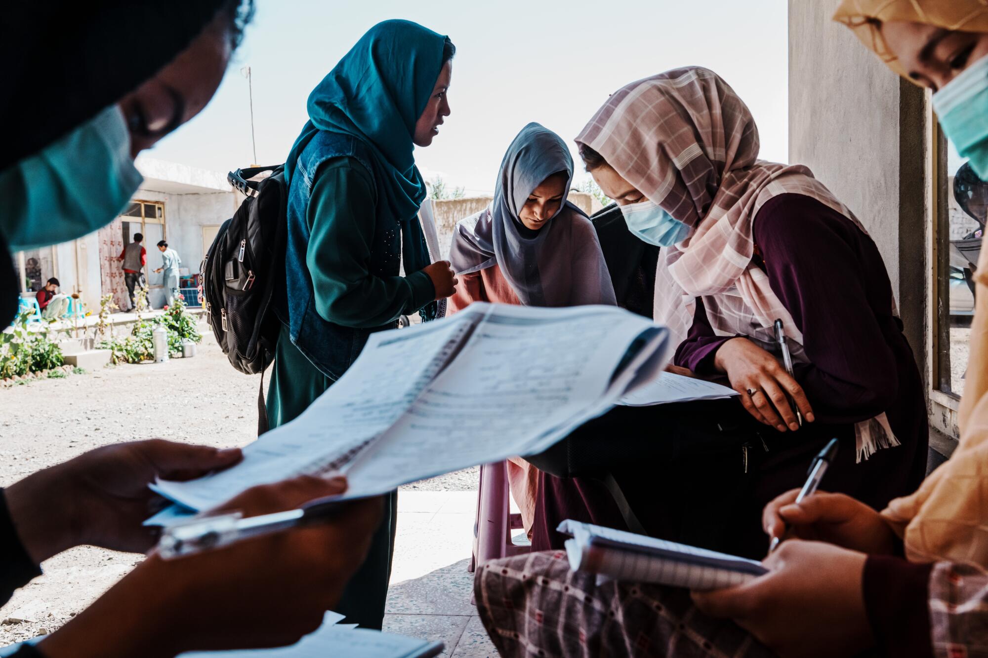 Meena Ibrahimi, 20, center, and other students study for the Kankor exam.
