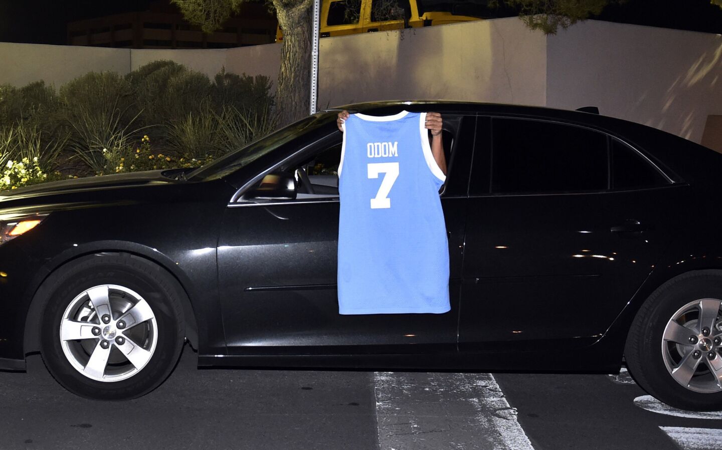 A driver displays a basketball jersey with Lamar Odom's name as the driver exits Sunrise Hospital and Medical Center on Oct. 13, 2015, in Las Vegas. The former NBA basketball player was hospitalized after he was found unconscious Tuesday at a Nevada brothel, authorities said.
