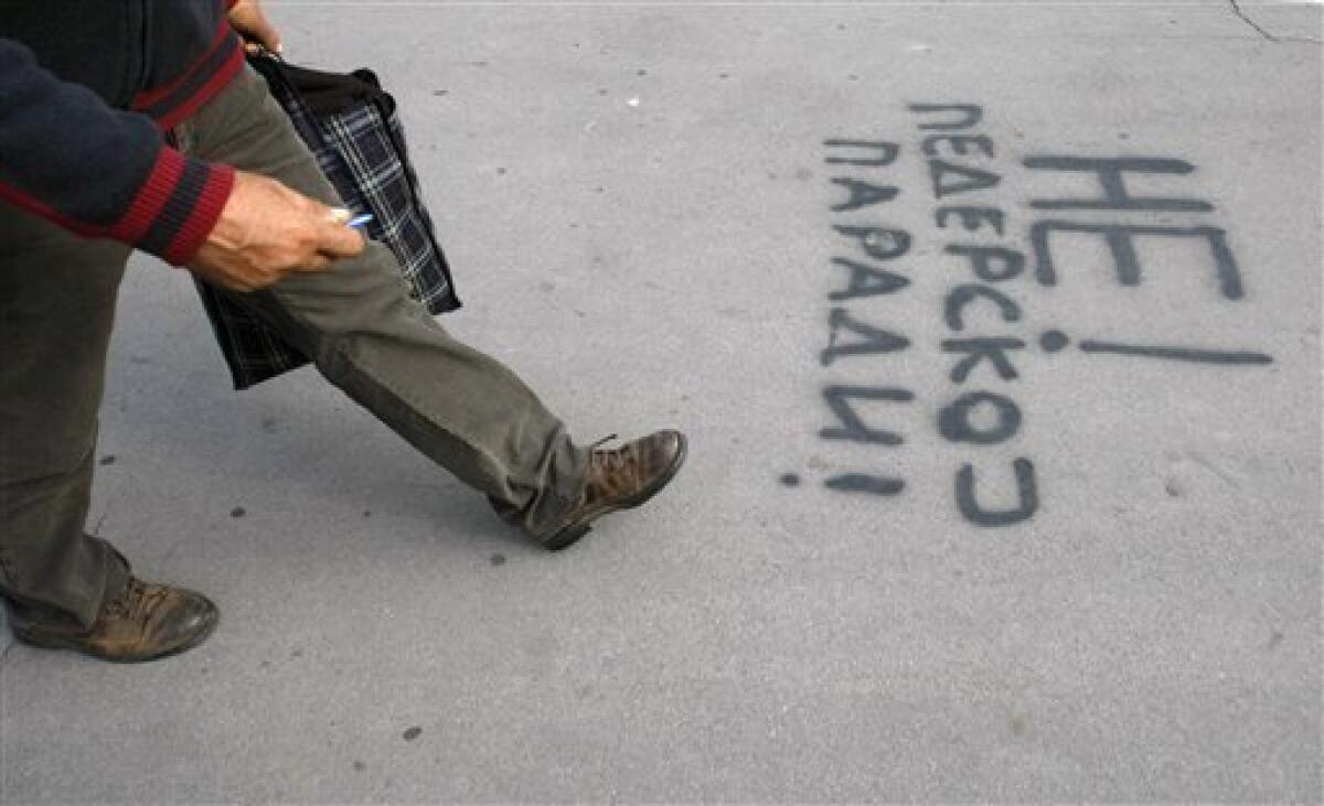 A man walks by a graffiti that reads "No to the gay parade" in Serbian Cyrillic letters in Belgrade, Serbia, Friday, Oct. 8, 2010. This weekend's staging a gay pride march will be a major test for Serbia's democracy after extremists forced the cancellation of last year's event, international human rights organizations said. (AP Photo/Andrej Cukic)