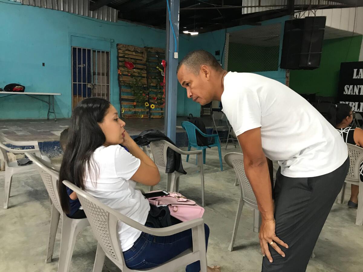 Pastor Pedro González talks with a woman.