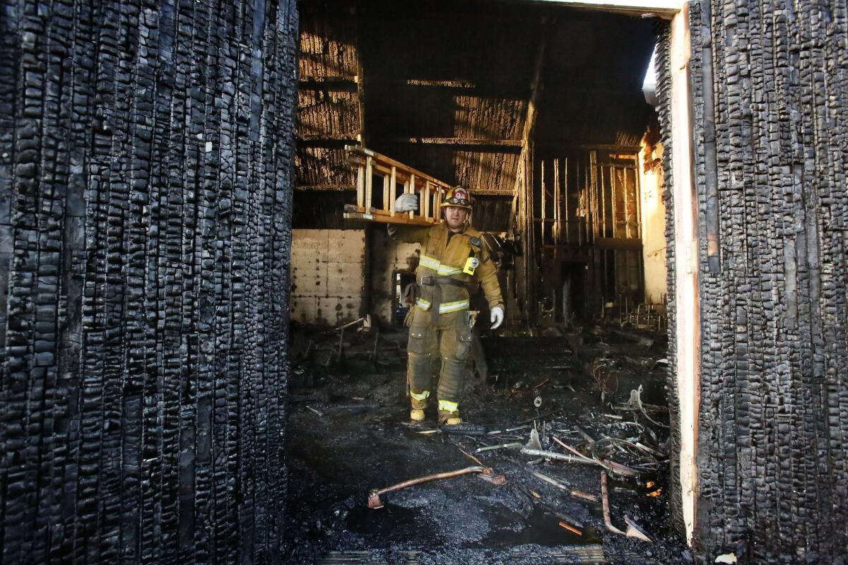 Los Angeles firefighter George Romero walks through what's left of the Bethesda Temple Church on Crenshaw Boulevard after an early morning blaze gutted the interior.