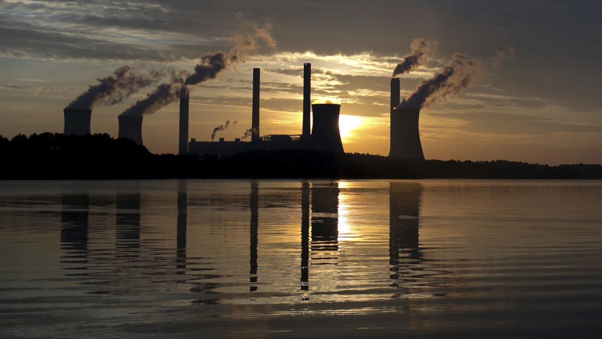 The sun sets behind Georgia Power's coal-fired Plant Scherer, one of the nation's top carbon dioxide emitters, in Juliette, Ga.