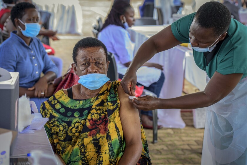 FILE - A woman receives a coronavirus vaccination at the Kololo airstrip in Kampala, Uganda on May 31, 2021. Uganda has its first seven cases of the omicron variant of the coronavirus, a health official confirmed Tuesday, Dec. 7, 2021, saying the variant was detected in travelers from South Africa and Nigeria who arrived in Uganda on Nov. 29. (AP Photo/Nicholas Bamulanzeki, File)