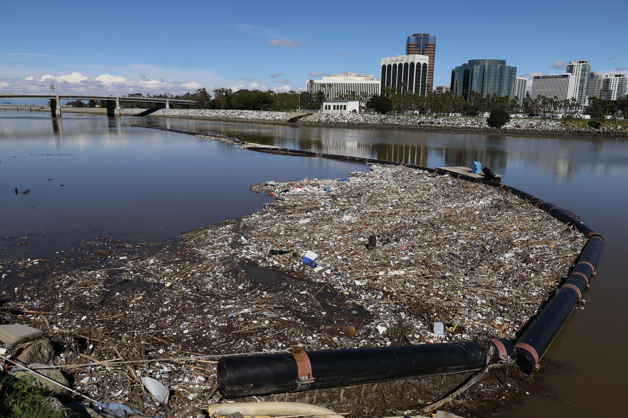 Following heavy rain in recent days, trash is trapped in a trash boom in the Los Angele River in Long Beach.