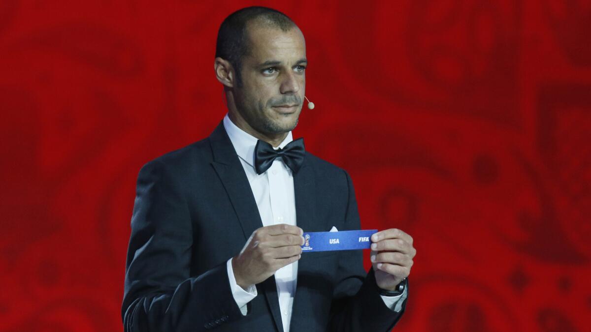 Portuguese beach soccer player Madjer holds the United States tag during the preliminary draw for the 2018 World Cup in St. Petersburg, Russia, on Saturday.