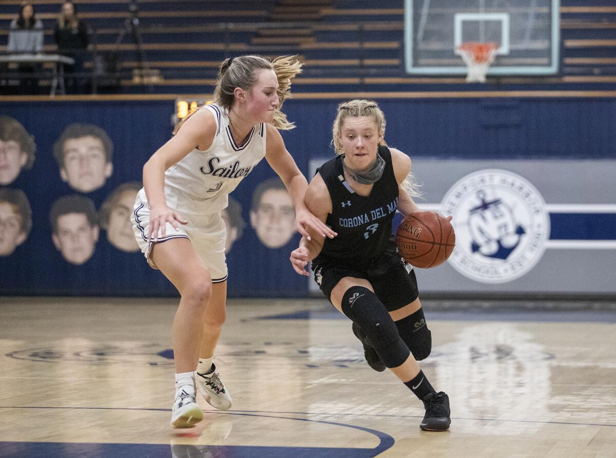 Corona del Mar's Haley Esquino drives to the hoop under pressure from Newport Harbor's Kate Bland on Jan. 20.