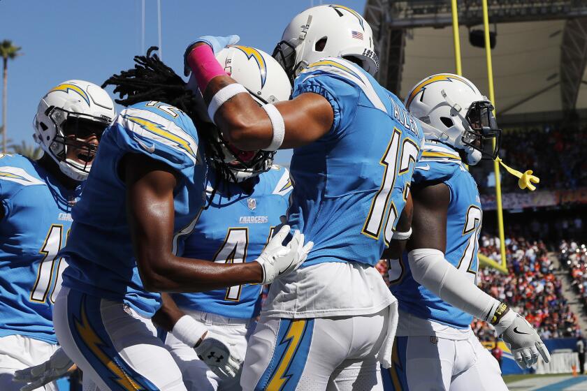Chargers wide receiver Travis Benjamin, middle, is congratulated by teammate Keenan Allen (13) after scoring on a 65-yard return during the first half.