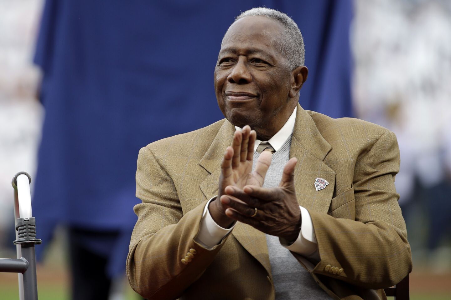 Hank Aaron applauds during a ceremony celebrating the 40th anniversary of his 715th home run