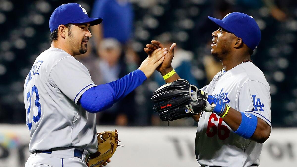 Dodgers teammates Adrian Gonzalez, left, and Yasiel Puig celebrate the team's 4-3 win over the New York Mets on Wednesday.
