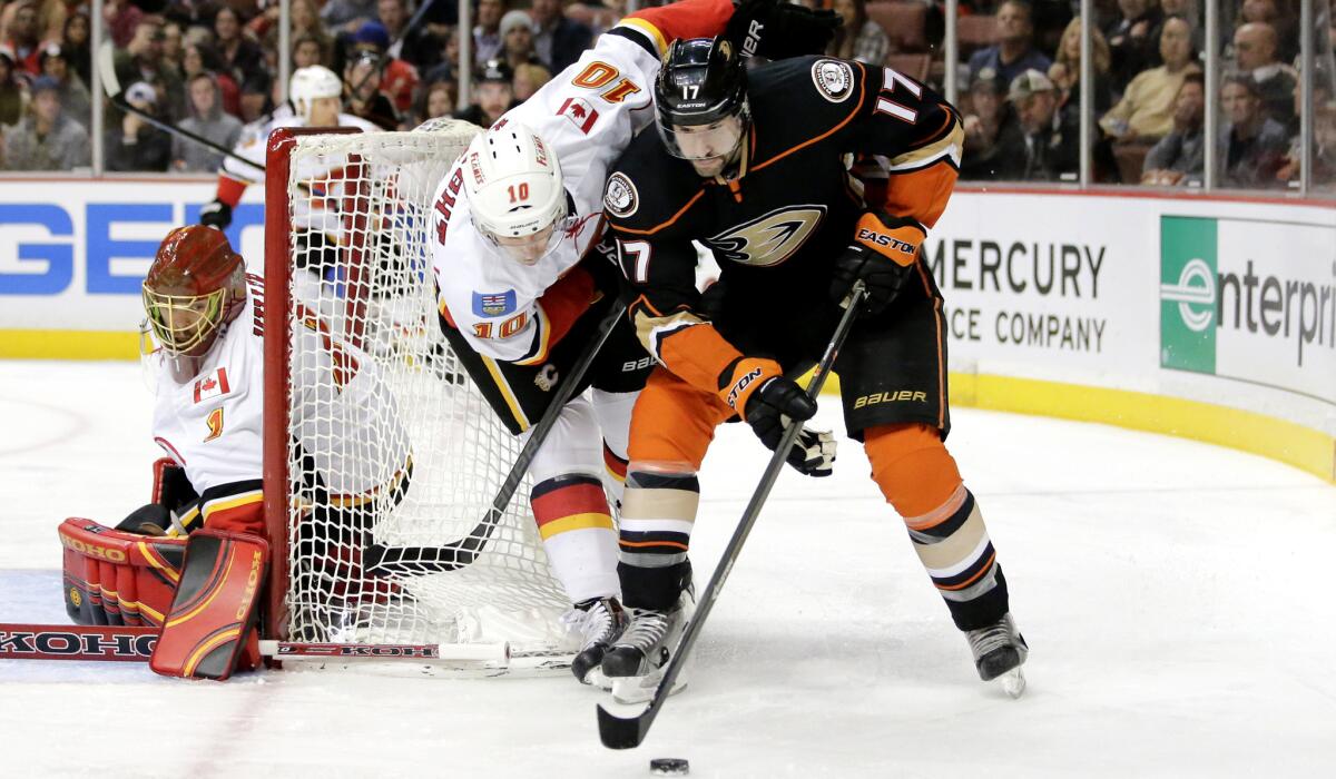 Ducks center Ryan Kesler takes the puck around the goal as he's defended by Calgary's Corban Knight in the second period Wednesday night.