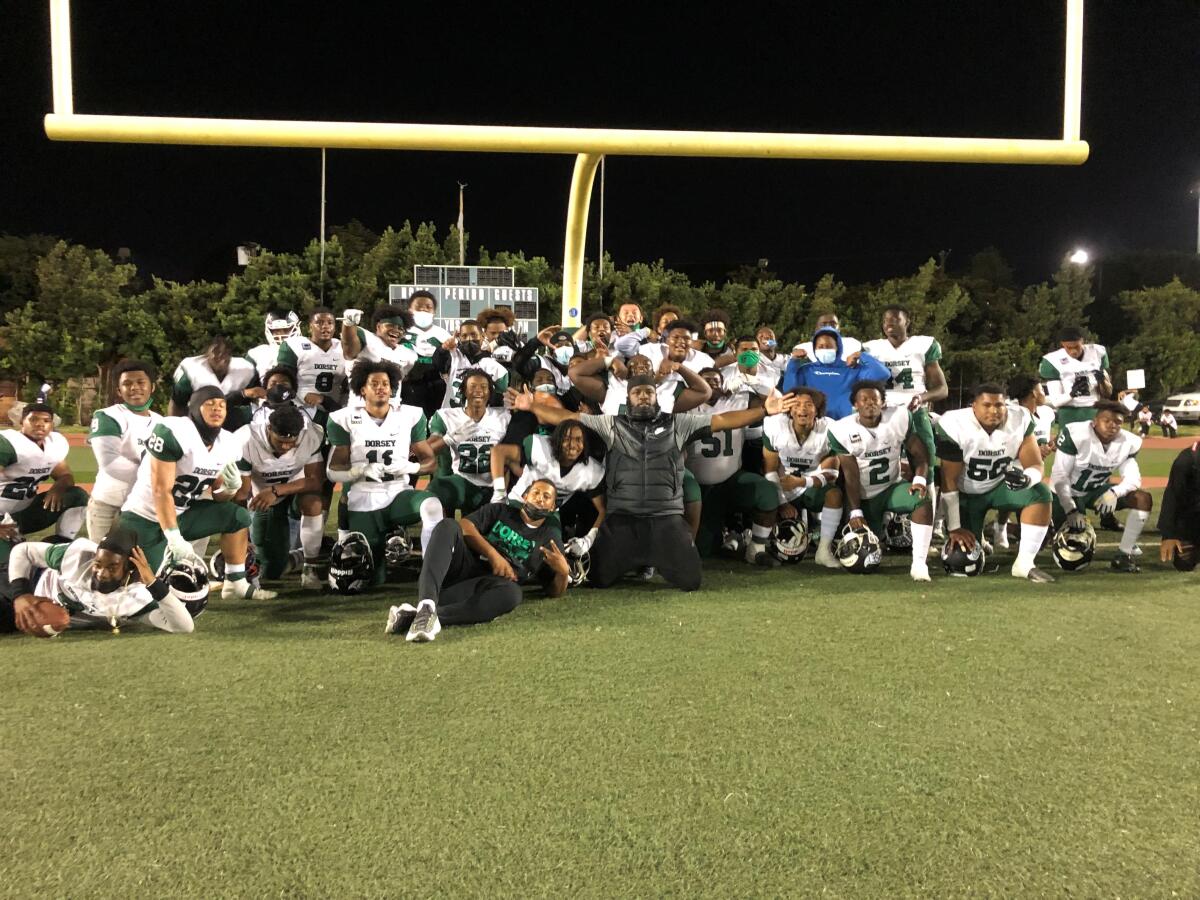 The Dorsey High football team poses for a photo after defeating Santa Monica on on Friday night at Jackie Robinson Stadium.