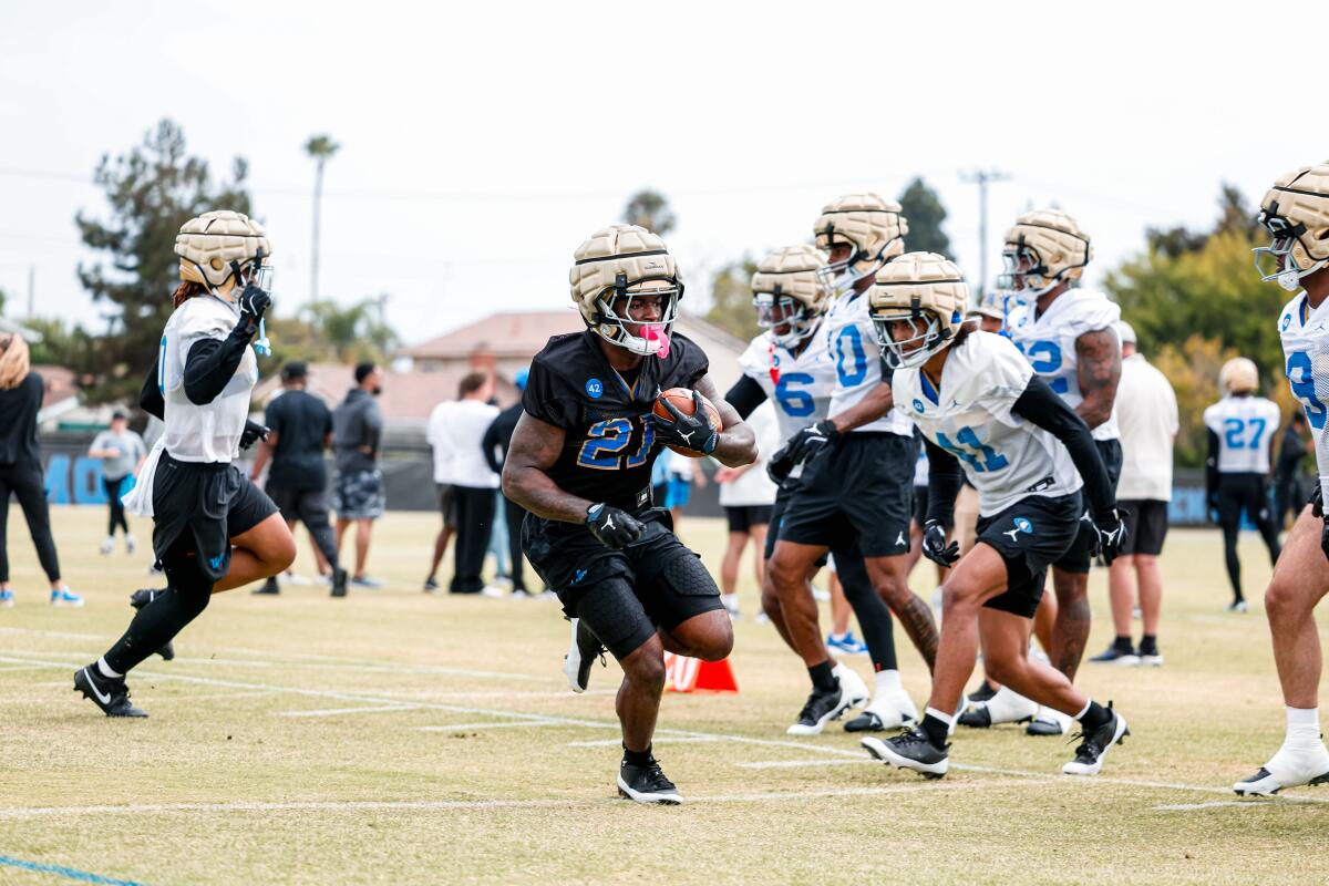 UCLA, Jaivian Thomas'ın geri koşması, Costa Mesa'daki sezon öncesi eğitim sırasında topu taşıyor.
