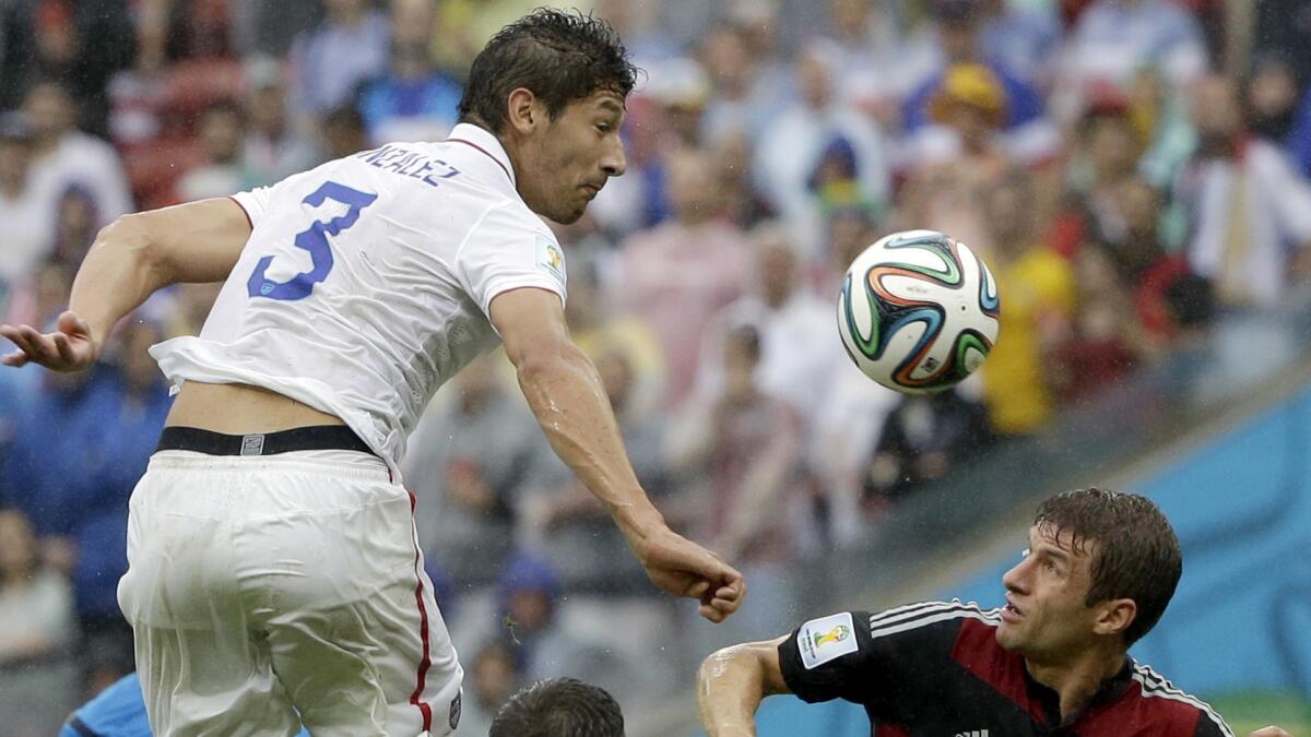 U.S. defender Omar Gonzalez, left, heads the ball over Germany forward Thomas Mueller during the USA's 1-0 loss at the World Cup on Thursday. Gonzalez played a major role in holding the Germans to just one goal.