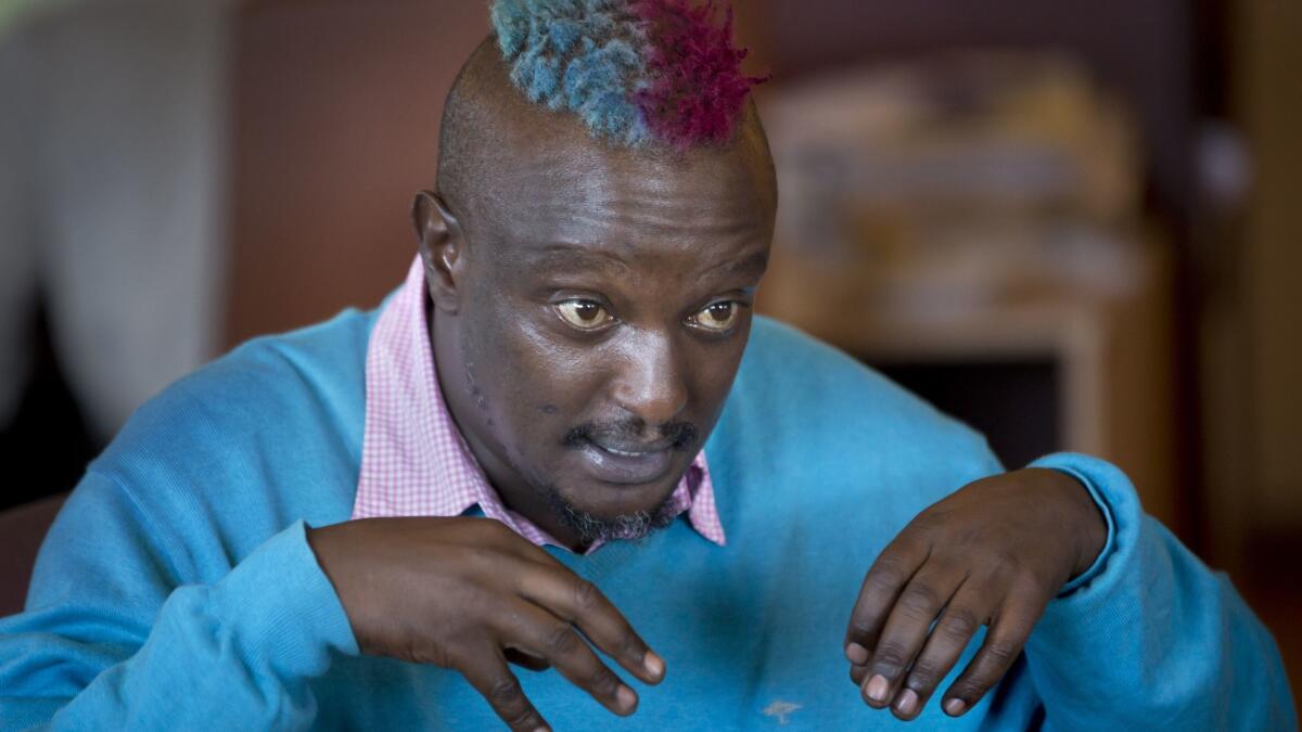 Kenyan author Binyavanga Wainaina, who won the 2002 Caine Prize for African Writing, speaks during a television interview in Nairobi in 2014.