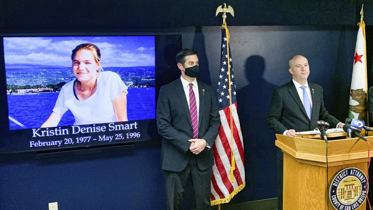 San Luis Obispo District Attorney Dan Dow announces a murder charge is filed against Paul Flores in the Kristin Smart case, as Deputy District Attorney Chris Peuvrelle listens at left, during a news conference, Wednesday, April 14, 2021, in Arroyo Grande, Calif. Smart, a missing California college who was killed in 1996 during an attempted rape by a fellow student, and the suspect’s father helped hide her body, the San Luis Obispo County district attorney said Wednesday. (David Middlecamp/The Tribune (of San Luis Obispo) via AP)