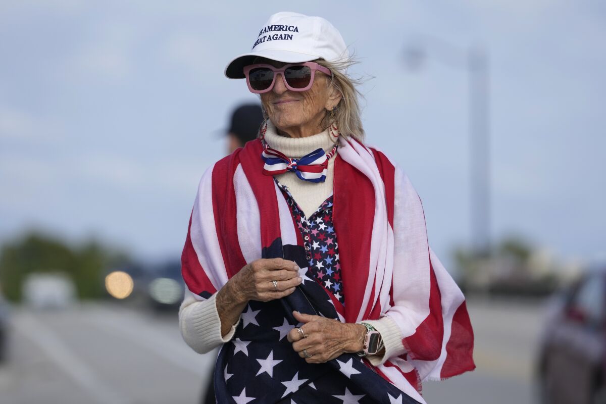 Evelyn Knapp, a supporter of former President Donald, walks outside of Trump's Mar-a-Lago estate, Monday, March 20, 2023, in Palm Beach, Fla. (AP Photo/Lynne Sladky)